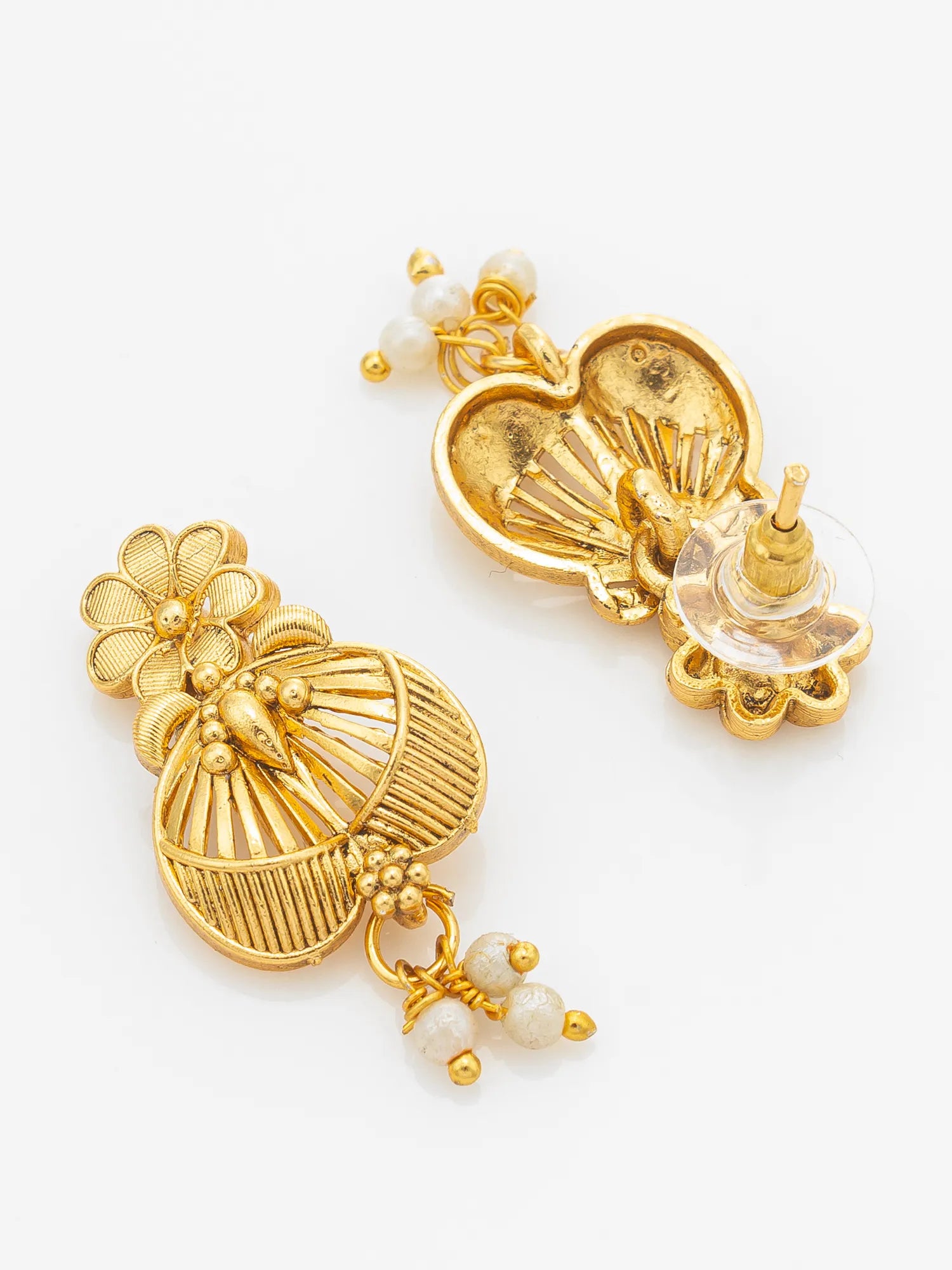 A pair of gold-toned traditional Indian dangle earrings with white pearl-like bead accents, displayed on a clean white background.