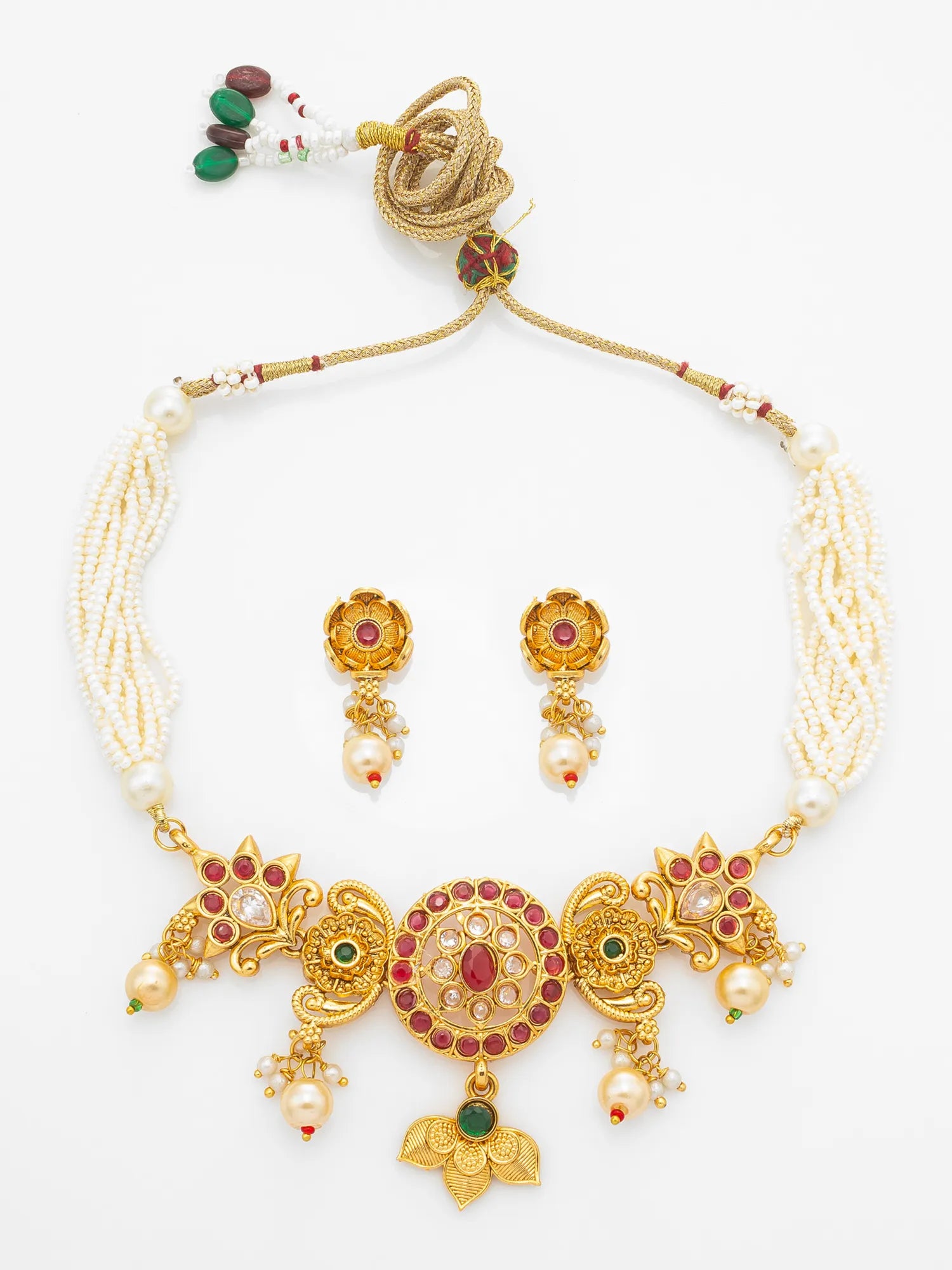 Gold-plated traditional Indian jewelry set featuring a statement necklace and matching earrings. The necklace is adorned with white pearl strands, a large central medallion decorated with red and green stones, and dangling gold elements with pearl accents.