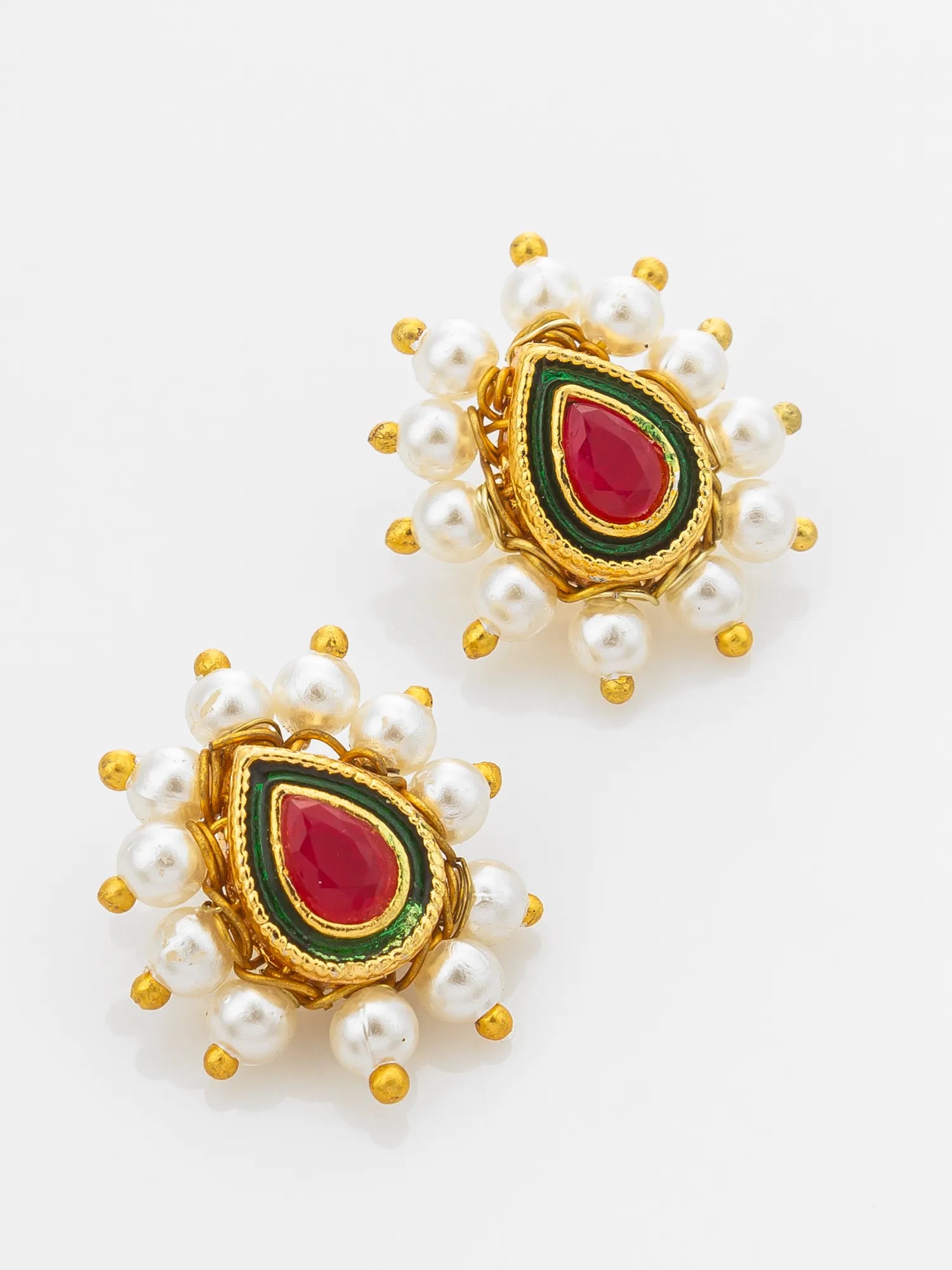 A pair of gold-plated earrings decorated with white faux pearls, featuring a central teardrop-shaped red stone surrounded by green and gold enamel, set against a plain white background.