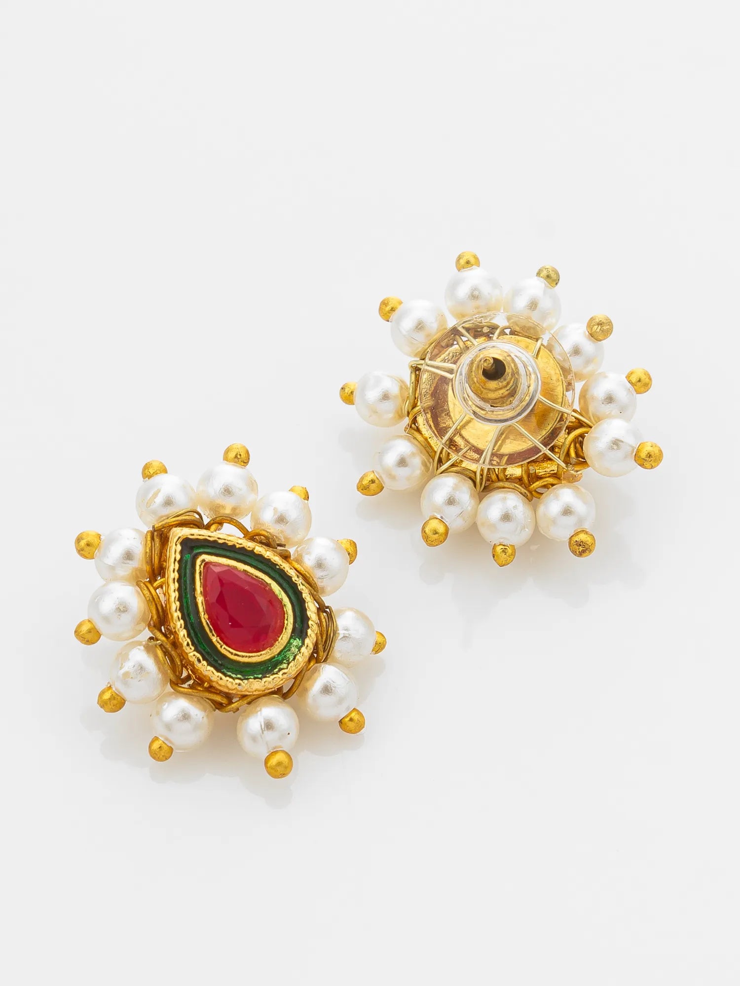 A pair of gold-plated Indian jhumka earrings decorated with white faux pearls and a central red teardrop-shaped stone bordered by green and gold enamel.