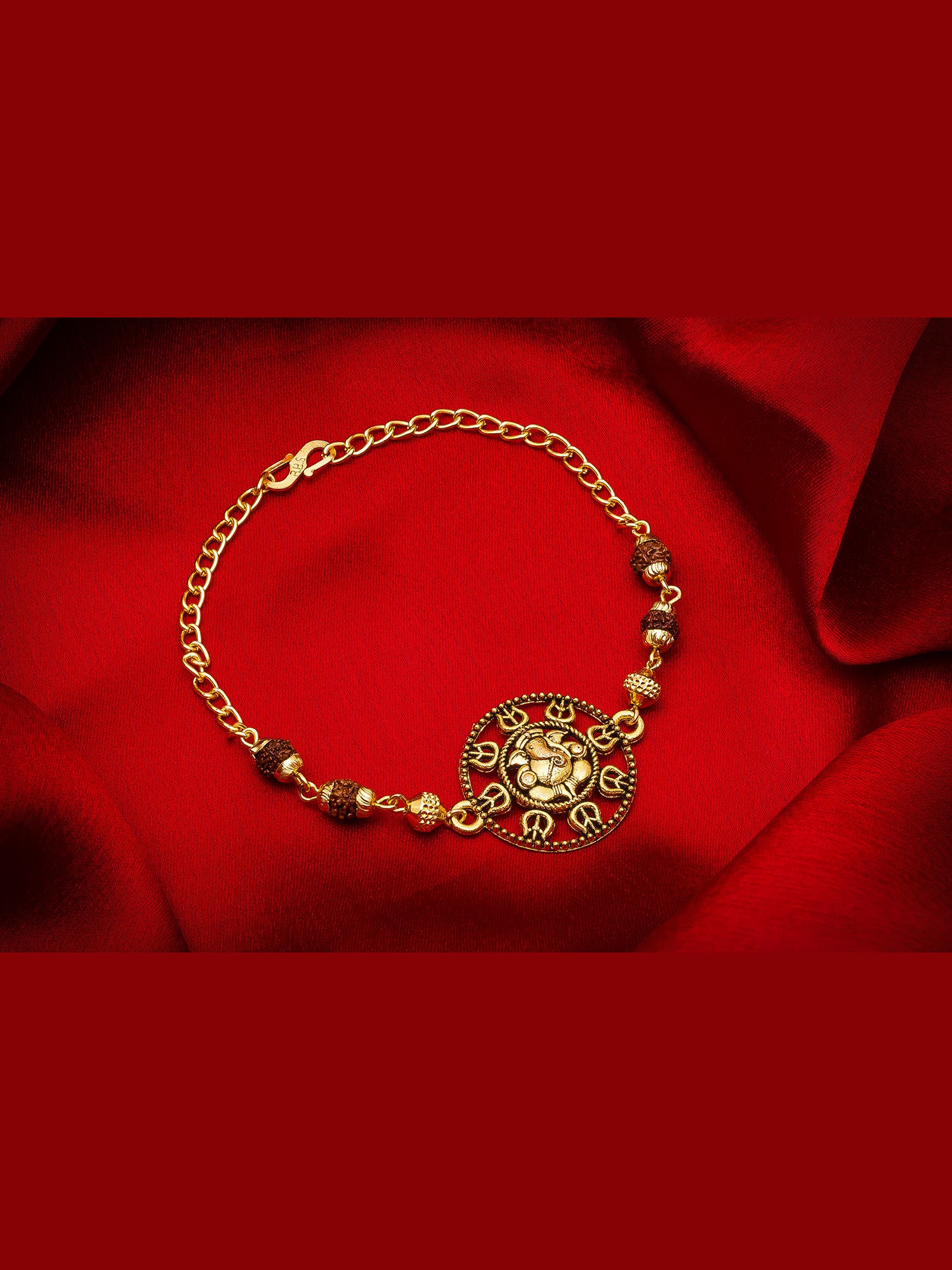 Gold bracelet with decorative elements on a red fabric background
